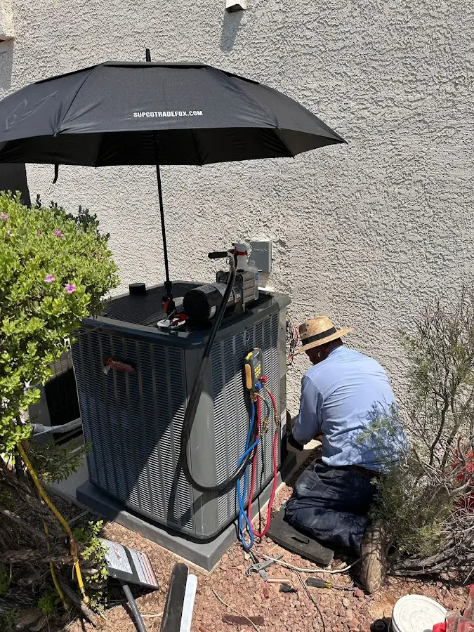 HVAC technician performing outdoor AC maintenance in Gulf Hills